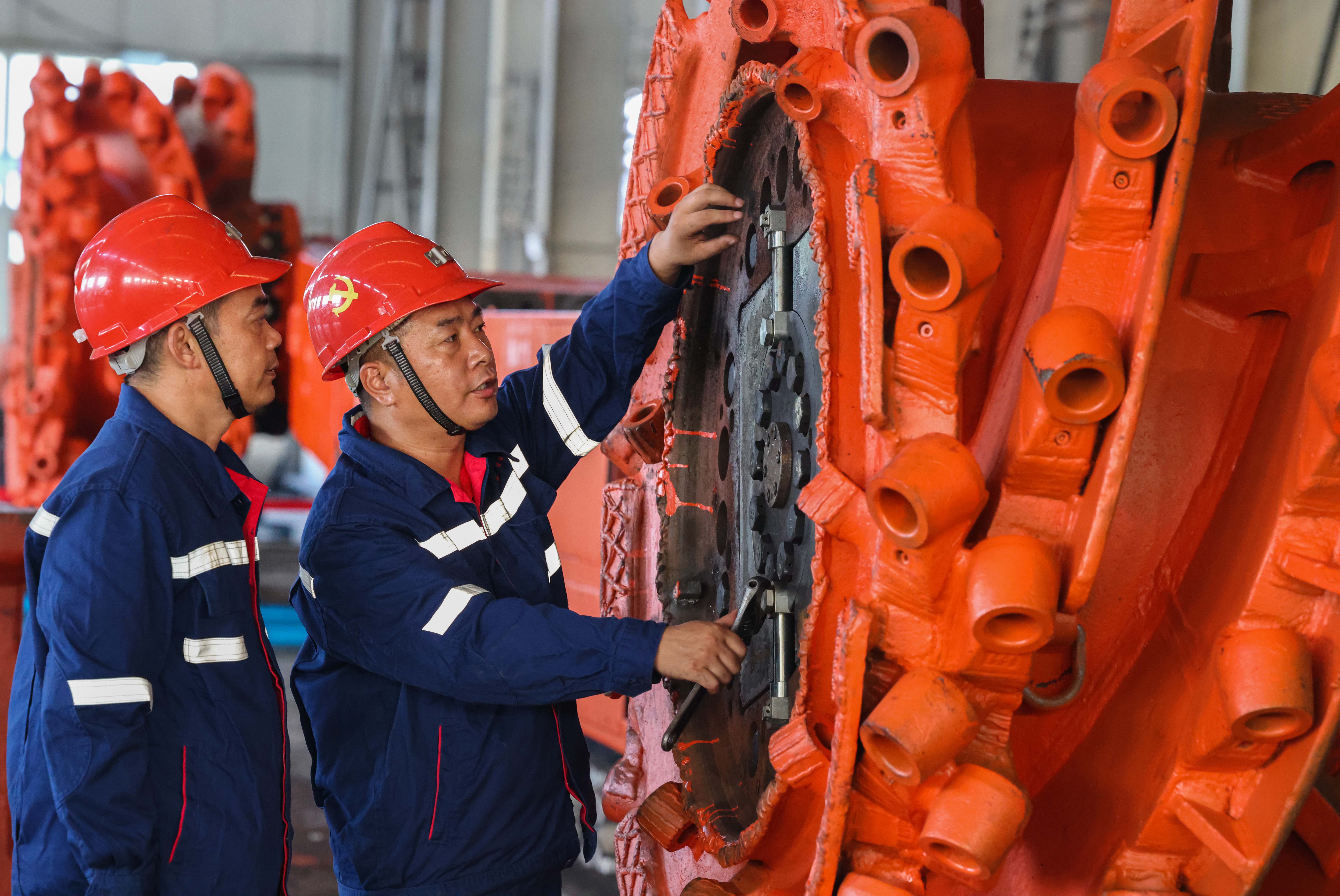 淮北礦業(yè)集團“工匠大師工作室”核心成員王忠才和徒弟共同探討綜采機維修技巧。鄭洪光攝